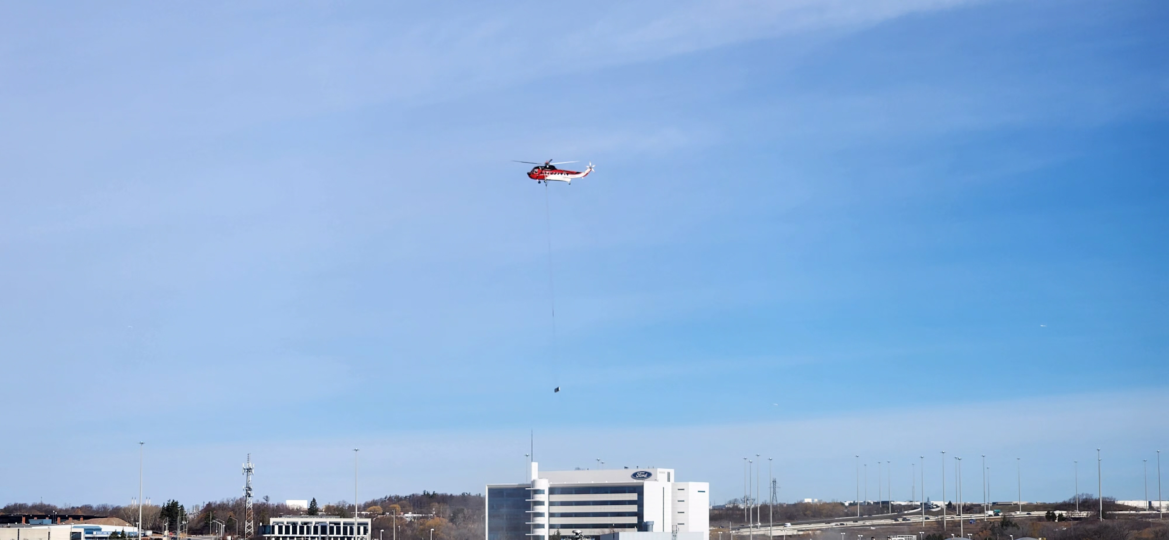 In this March 30, 2024, photo, a helicopter carries a beam to prepare for the transformation of the Ford Oakville Assembly Plant in Oakville, Ontario. The comprehensive overhaul of the plant from a gas vehicle assembly plant into an EV manufacturing complex is set to begin in the second quarter. 